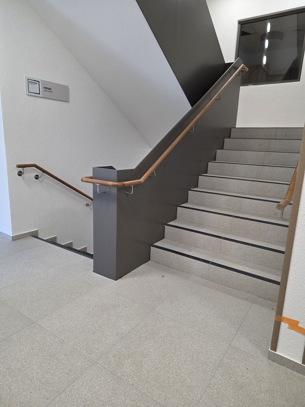 Treppenhaus mit Stahlgeländer und Holzhandlauf